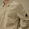 Camisa sobre de Taylon P con bolsillos en el pecho y botones en forma de Lens