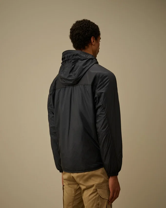 Chaqueta con capucha y detalle de lente «Lens» de Nada Shield, confeccionada con Primaloft® Evolve y plegable
